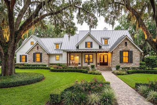 Stone and board-and-batten Midwestern home with trimmed hedges and a brick walkway
